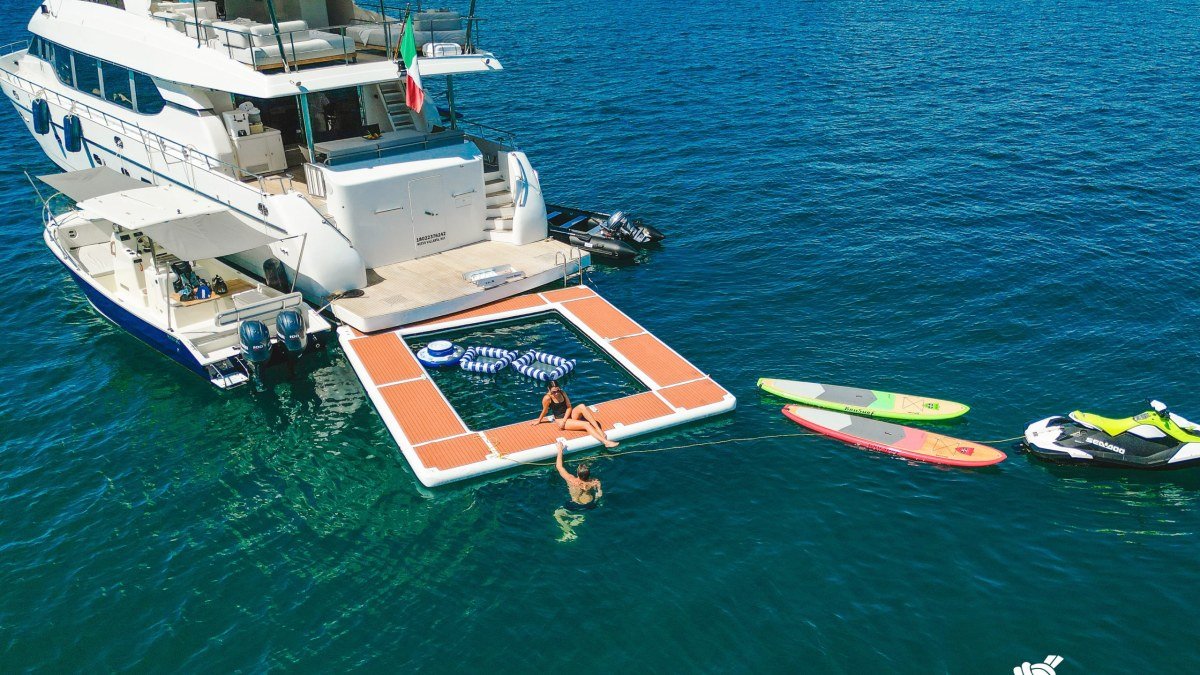 Guests on a floating lily pad and paddleboards beside the 84 ft Montefino yacht anchored off the Punta Mita coast