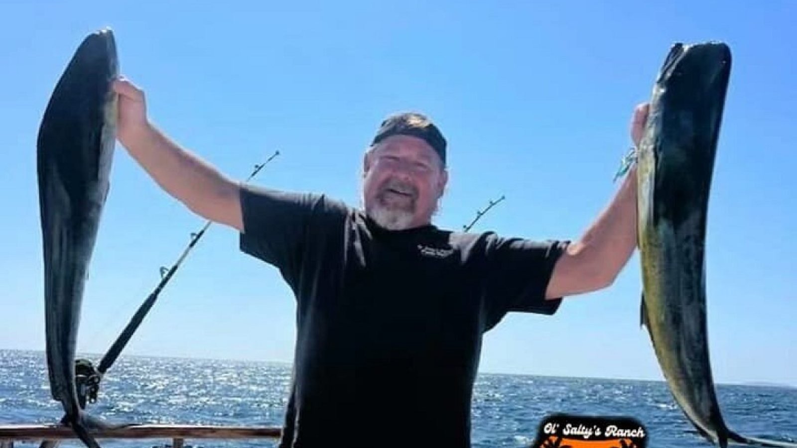 Smiling angler holding up two dorado on a private fishing charter in Banderas Bay, Puerto Vallarta