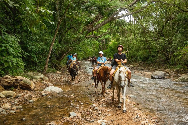 Horseback riders crossing the river in the Sierra Madre near Las Palmas